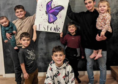 A group of boys smile while holding up butterfly drawings they created for Lupus Canada's Classrooms for a Cause initiative.
