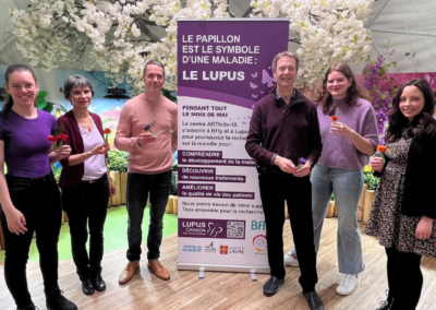 Dr. Paul Fortin and Dr. Boilard students smile while holding butterfly props at a lupus awareness event in Quebec.