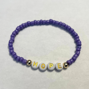 Purple beaded bracelet with gold-accented white beads spelling the word “HOPE” – symbol of lupus awareness and support.