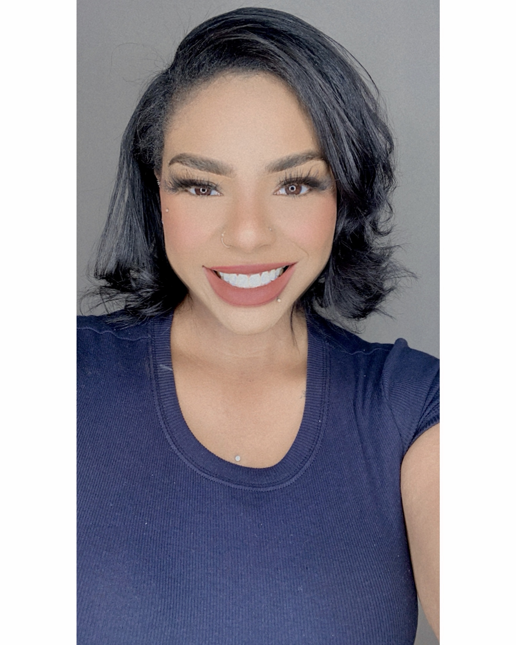 Portrait of Richelle Johnson, a smiling woman with short black hair and a navy blue shirt, photographed against a neutral background.