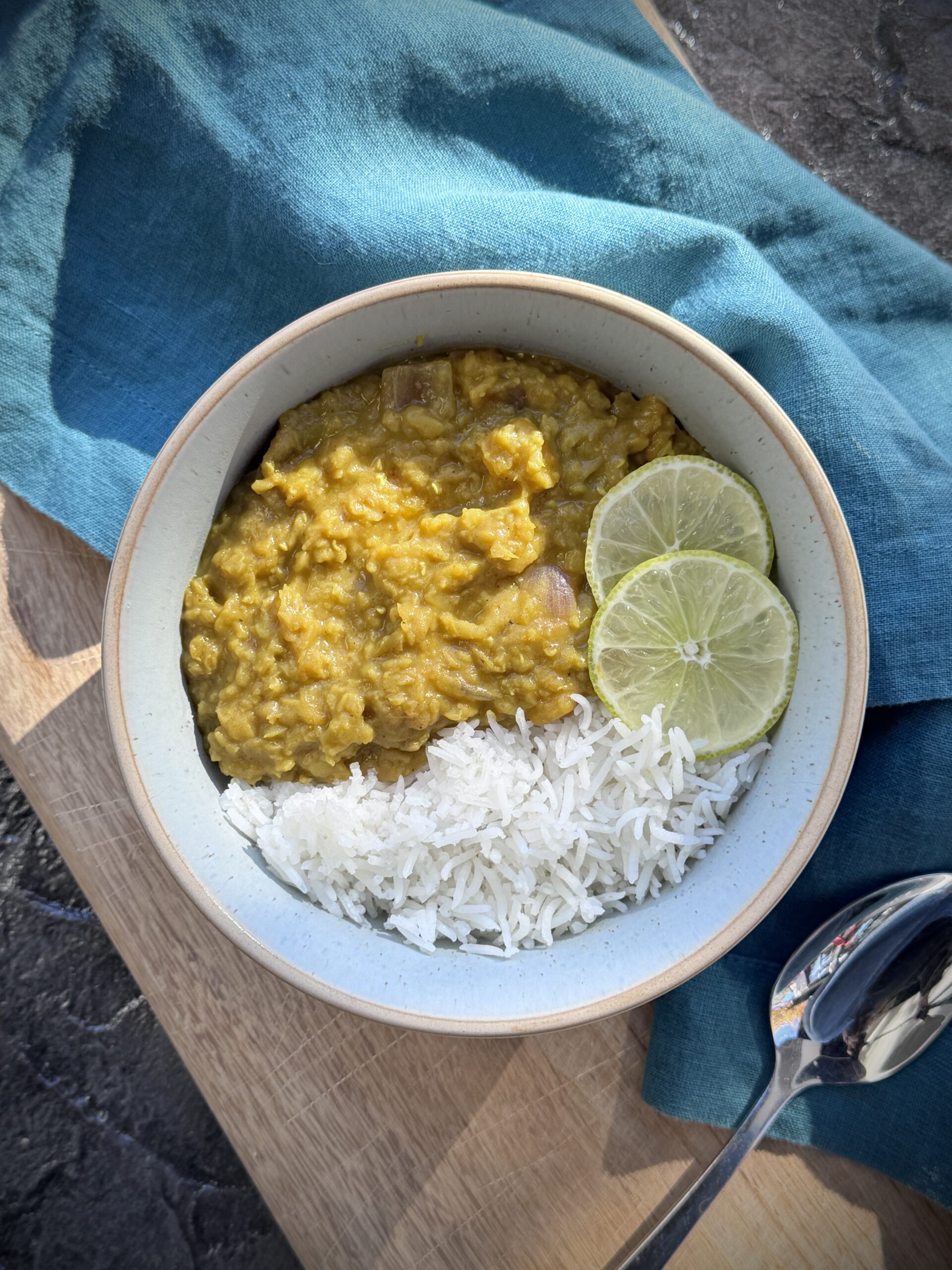 Cari anti-inflammatoire aux lentilles rouges et à la courge musquée – Lupus Canada Bol de curry anti-inflammatoire aux lentilles rouges et courge musquée servi avec du riz blanc et des tranches de citron vert.