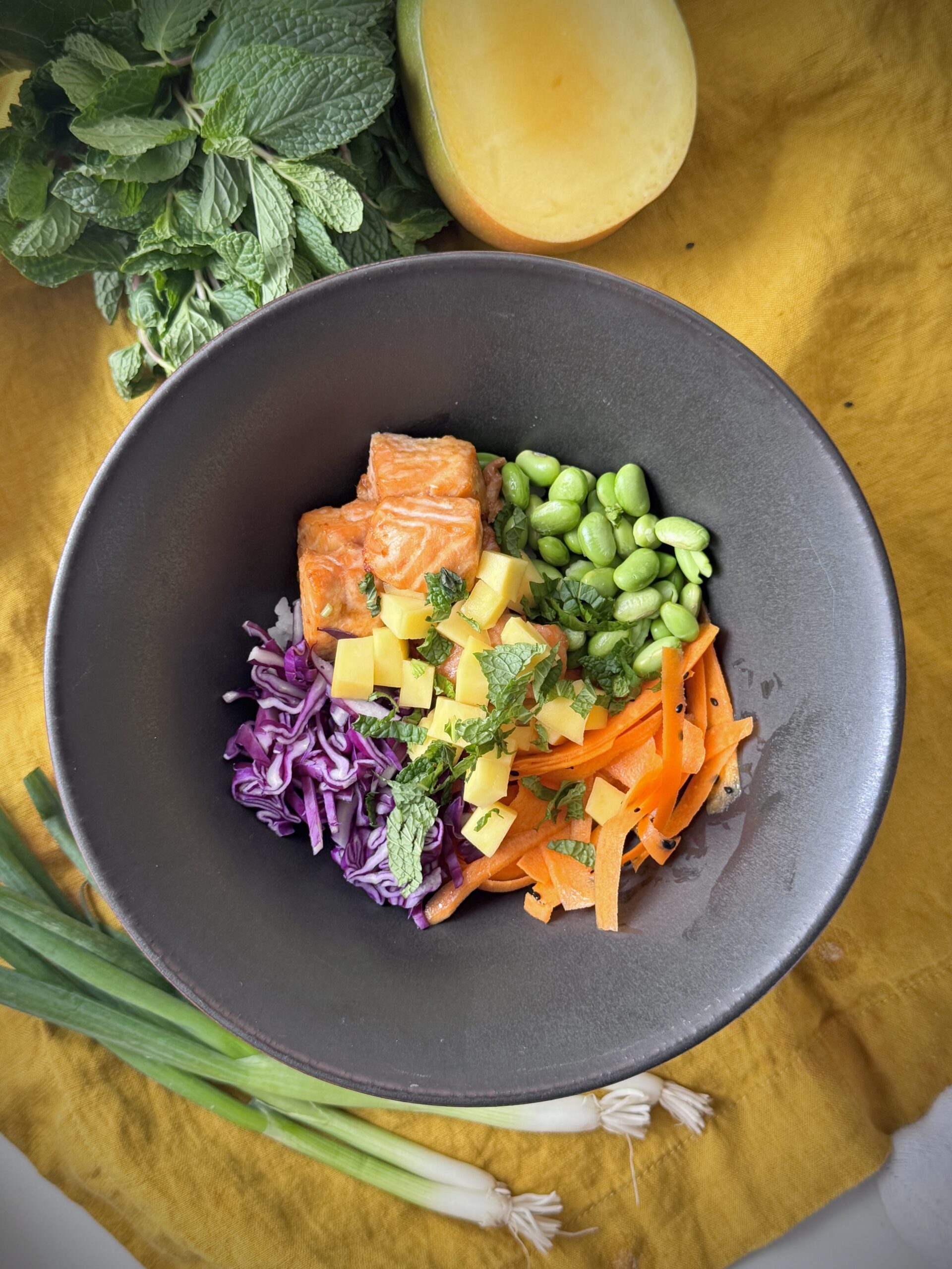 Ginger Salmon Bowl with rice, edamame, purple cabbage, carrots, mango and fresh mint