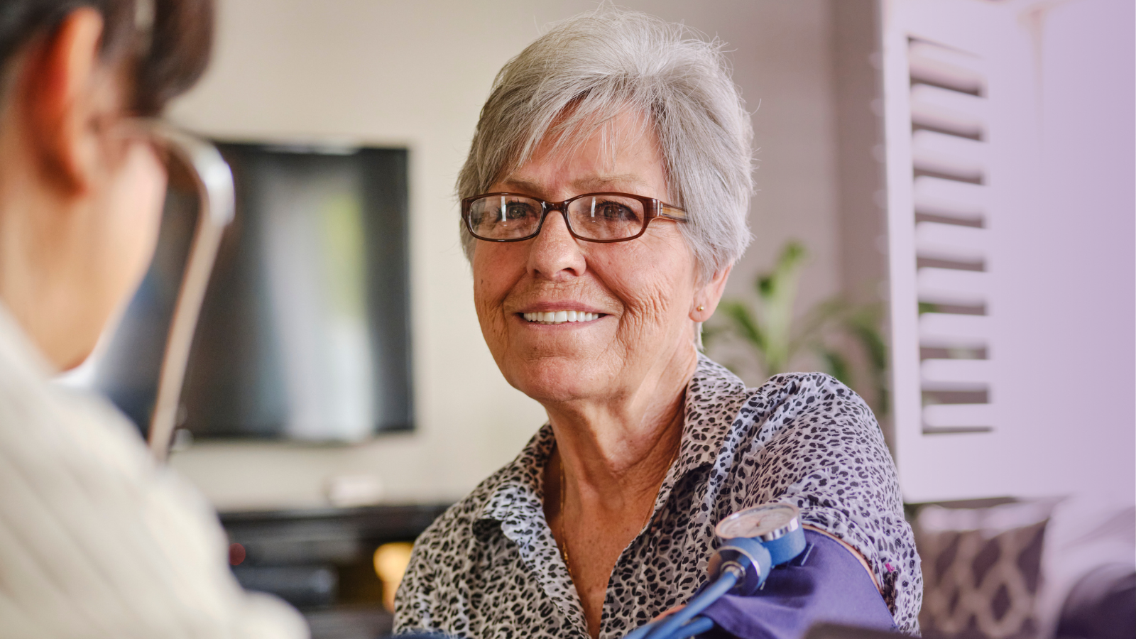 Femme âgée se faisant contrôler la tension artérielle par un professionnel de santé, représentant l’accès aux soins et vivant avec une maladie chronique au Canada