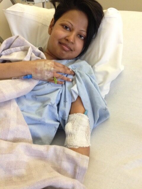 Gabrielle in hospital bed receiving treatment during a severe lupus flare while living with lupus
