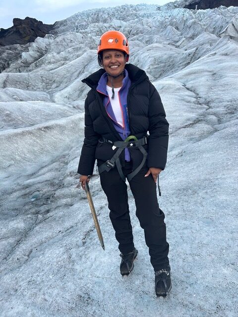 Gabrielle hiking on a glacier wearing safety gear, representing strength and recovery while living with lupus