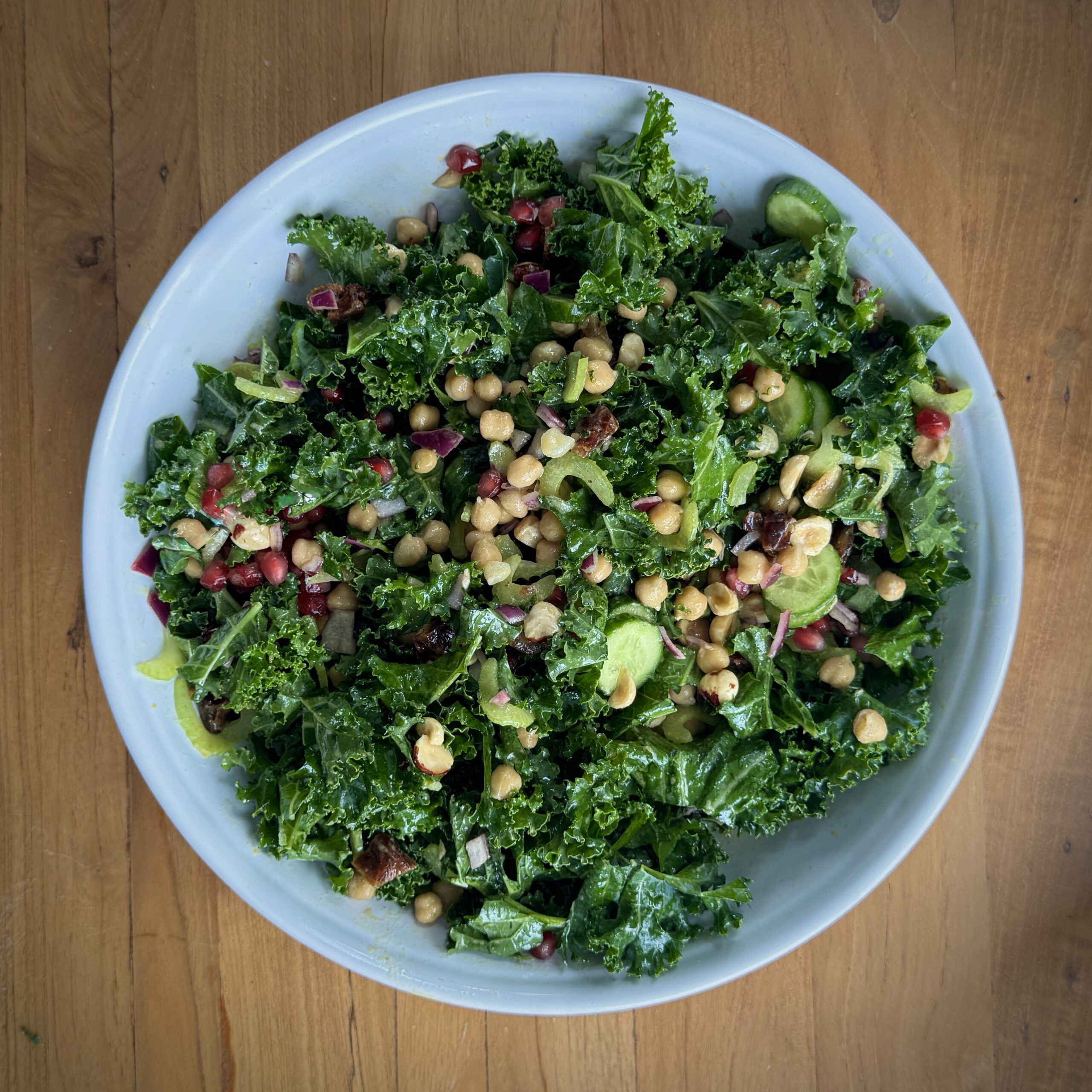 Salade de pois chiches au chou frisé avec concombres, graines de grenade, dattes et noisettes mélangées dans une vinaigrette Dijon au citron
