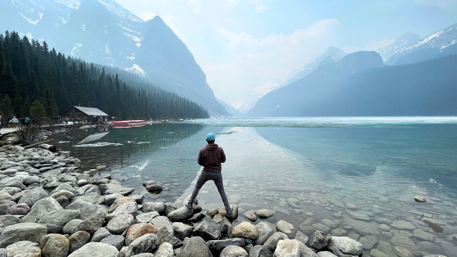 Isaac debout sur la rive rocheuse d’un lac de montagne au Canada