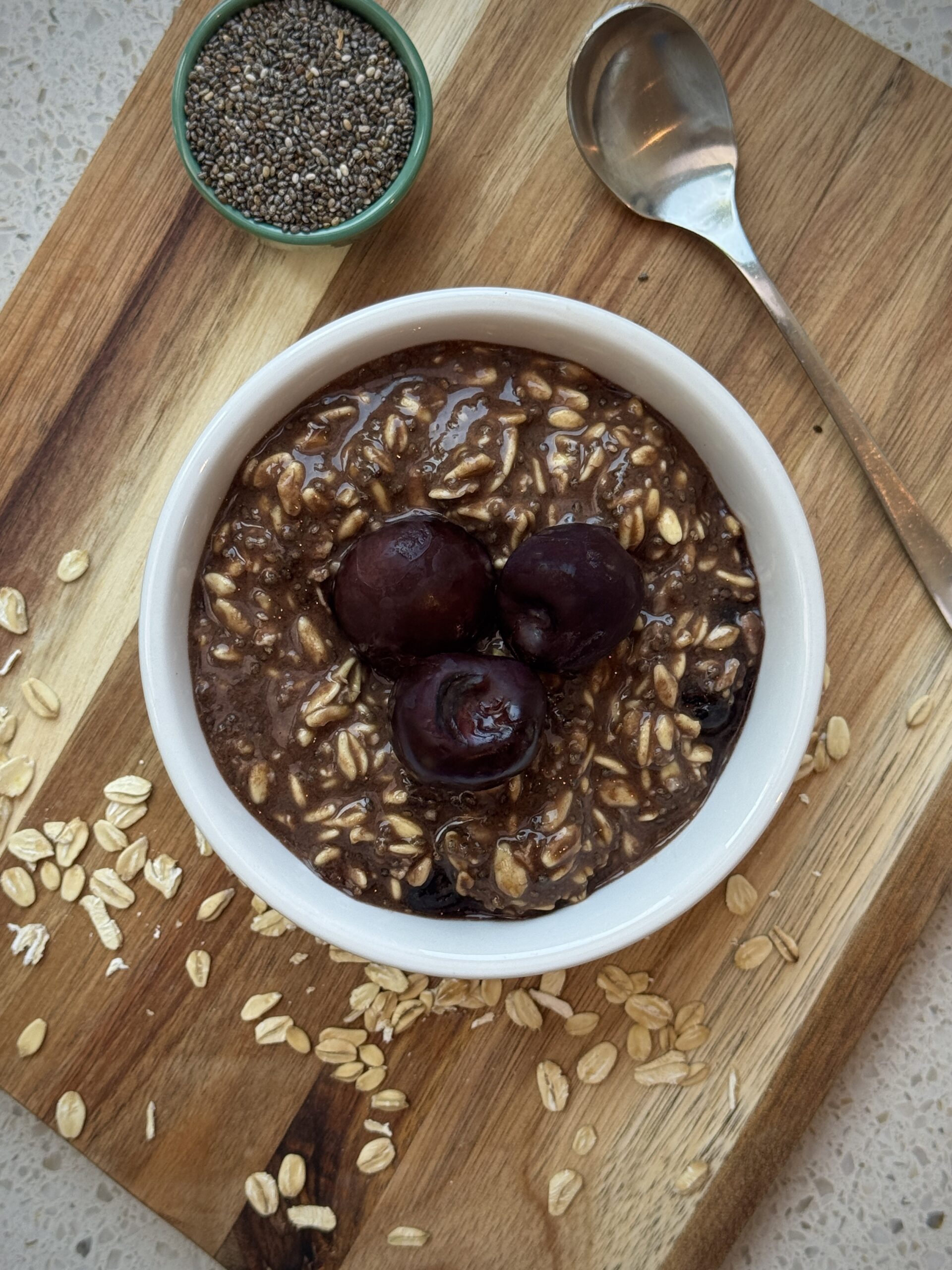 Black Forest Overnight Oats topped with cherries and served with rolled oats and chia seeds